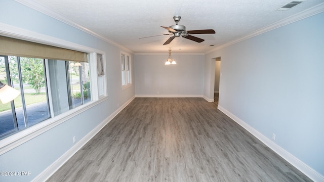 empty room with ceiling fan, hardwood / wood-style flooring, ornamental molding, and a textured ceiling