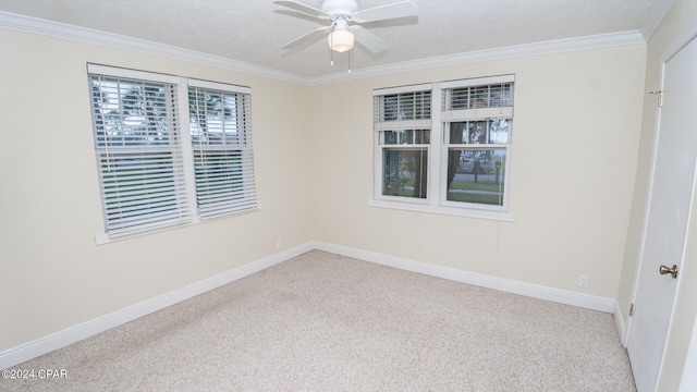 carpeted empty room featuring a textured ceiling, ceiling fan, and crown molding