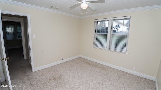 carpeted spare room featuring a textured ceiling, ornamental molding, and ceiling fan