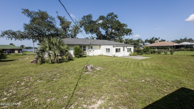 rear view of property with a patio and a yard