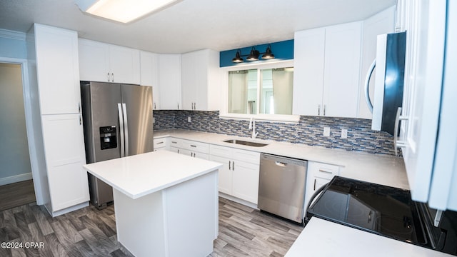 kitchen with sink, white cabinetry, appliances with stainless steel finishes, a center island, and dark hardwood / wood-style flooring