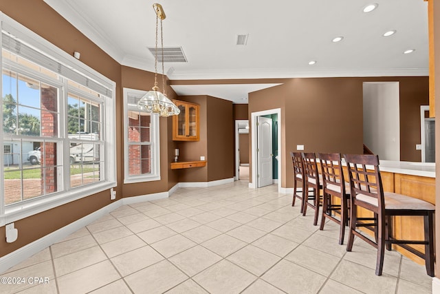 dining area featuring a notable chandelier, crown molding, and light tile patterned floors