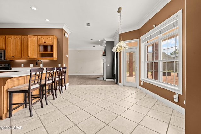 kitchen featuring ornamental molding, a kitchen breakfast bar, pendant lighting, and light tile patterned floors