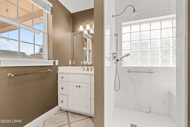 bathroom featuring a tile shower, tile patterned flooring, vanity, and ornamental molding