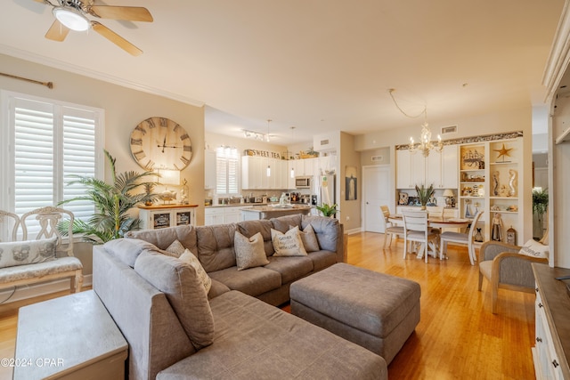 living room with ceiling fan with notable chandelier and light wood-type flooring