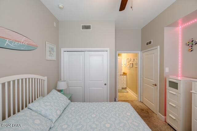 bedroom with light colored carpet, a closet, and ceiling fan