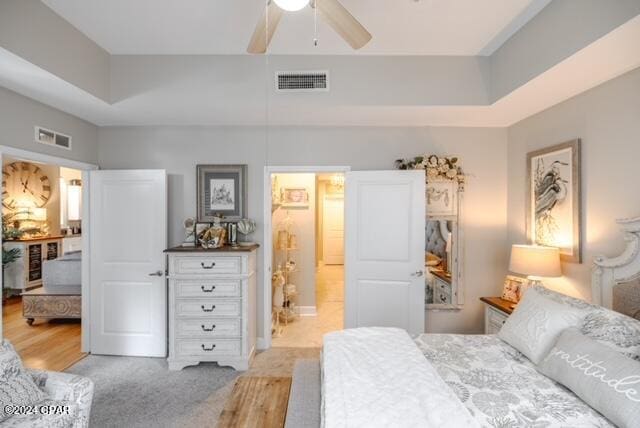 carpeted bedroom with ceiling fan and ensuite bathroom