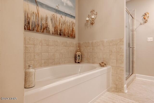 bathroom featuring tile patterned floors and independent shower and bath