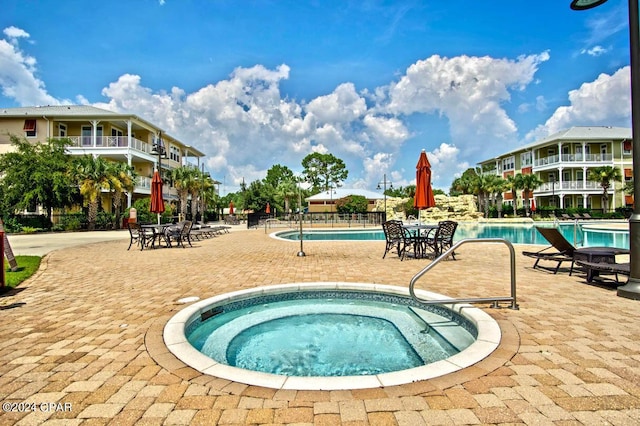 view of pool with a community hot tub and a patio area