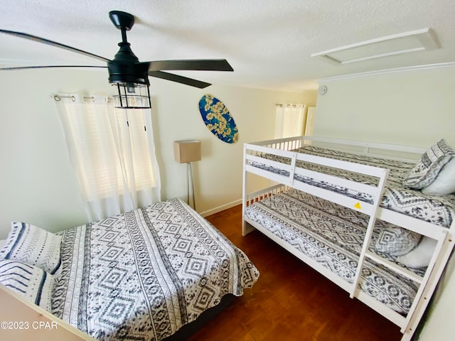 bedroom featuring a textured ceiling, dark wood-type flooring, and ceiling fan