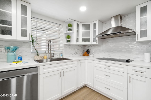 kitchen with dishwasher, wall chimney range hood, sink, and white cabinets