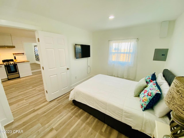 bedroom with light hardwood / wood-style floors and electric panel