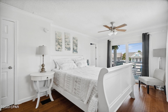 bedroom featuring ceiling fan, a textured ceiling, dark hardwood / wood-style floors, and ornamental molding