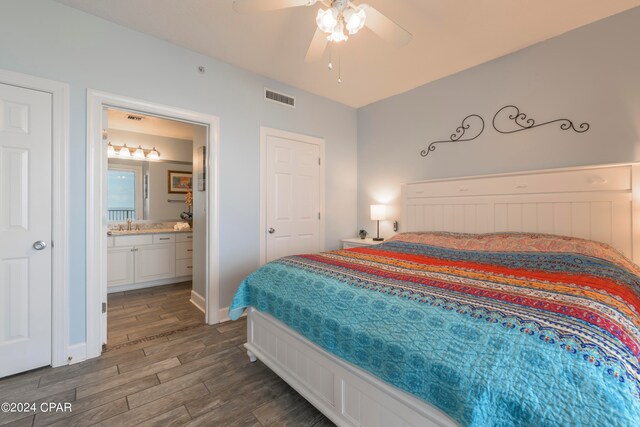 bedroom with ceiling fan, ensuite bath, and dark hardwood / wood-style floors