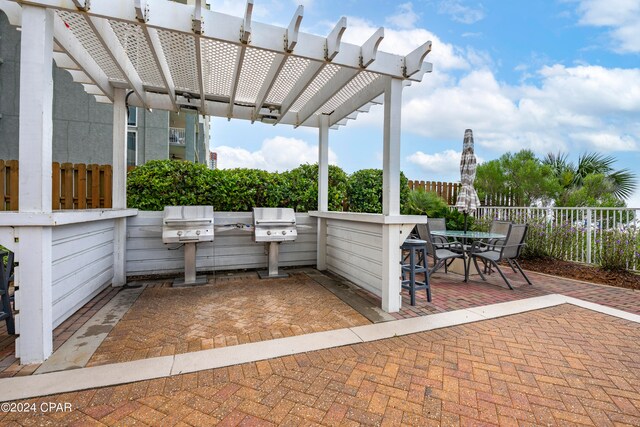 view of patio featuring a grill, a pergola, and an outdoor kitchen