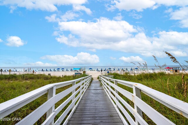 view of home's community with a water view and a beach view