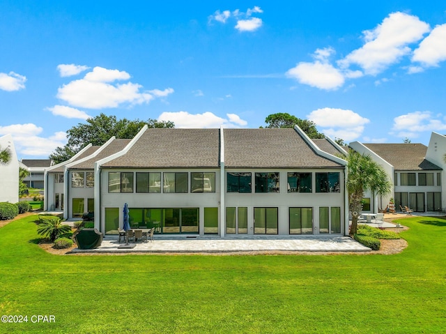 rear view of property featuring a lawn and a patio