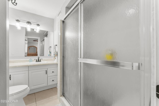 bathroom with vanity, toilet, an enclosed shower, and tile patterned floors