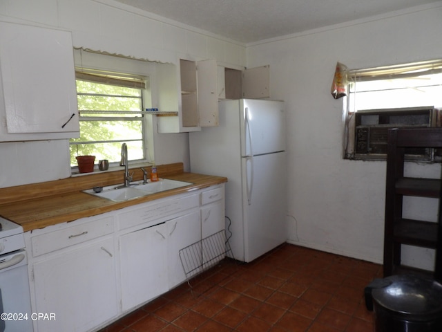 kitchen with wood counters, sink, white cabinetry, white fridge, and crown molding