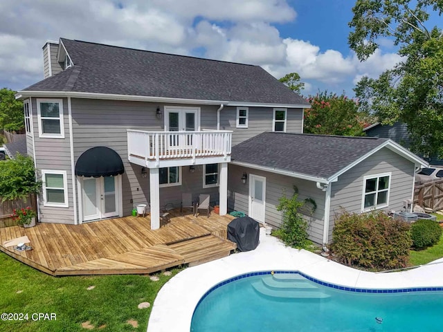 rear view of house featuring a pool side deck