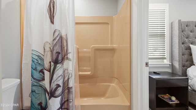 bathroom featuring shower / bath combo with shower curtain and toilet