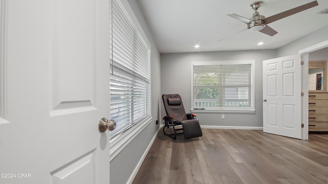 living area with ceiling fan and light hardwood / wood-style flooring