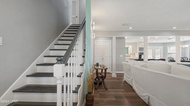 stairs with a notable chandelier and wood-type flooring