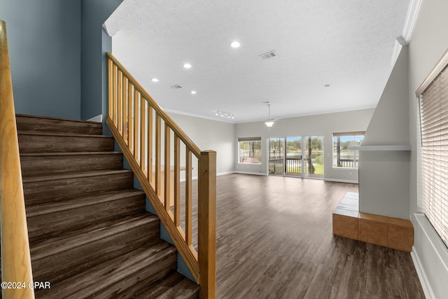 unfurnished living room with a wealth of natural light, a tiled fireplace, ceiling fan, and hardwood / wood-style flooring