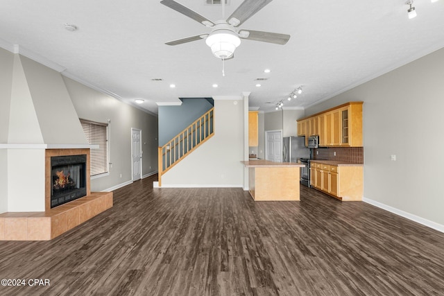 kitchen featuring a fireplace, ornamental molding, dark wood-type flooring, and ceiling fan