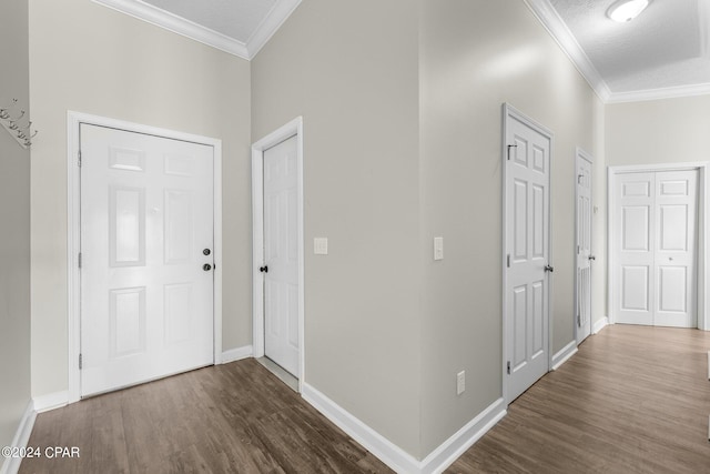 hallway with a textured ceiling, crown molding, dark hardwood / wood-style flooring, and a high ceiling