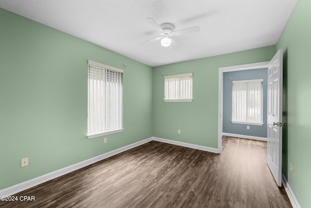 unfurnished bedroom with ceiling fan, a closet, and dark hardwood / wood-style floors