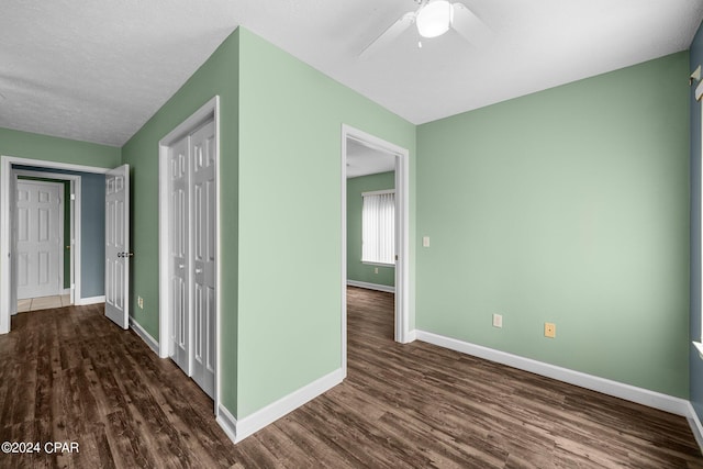 corridor featuring a textured ceiling and dark hardwood / wood-style flooring