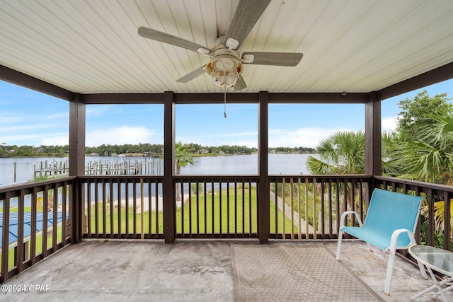 unfurnished sunroom featuring a water view and ceiling fan