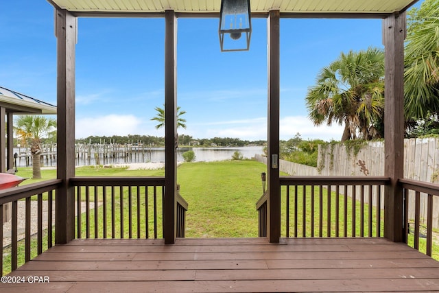 deck with a lawn and a water view