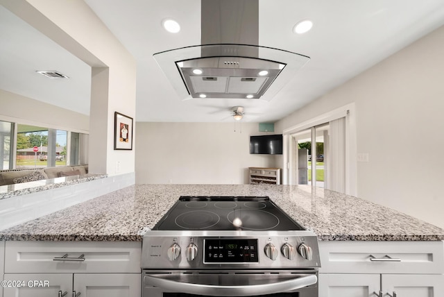 kitchen with stainless steel stove, white cabinetry, and a healthy amount of sunlight