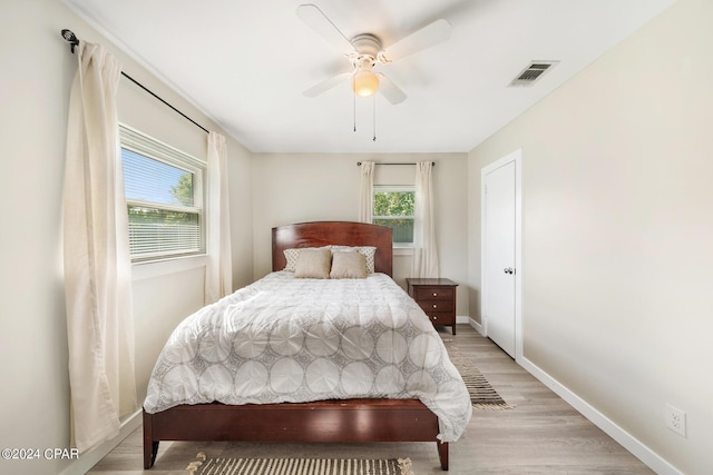 bedroom featuring light hardwood / wood-style floors, multiple windows, and ceiling fan