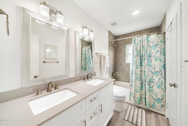 full bathroom featuring hardwood / wood-style flooring, vanity, toilet, and shower / tub combo with curtain