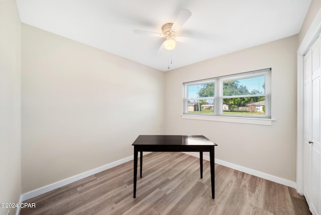 home office with light wood-type flooring and ceiling fan