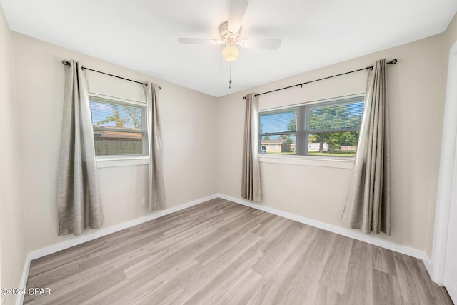 spare room with a wealth of natural light, light hardwood / wood-style flooring, and ceiling fan