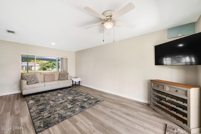 living room with ceiling fan and light wood-type flooring