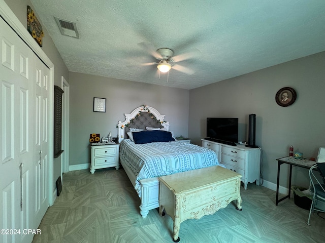 bedroom featuring a textured ceiling, ceiling fan, and a closet