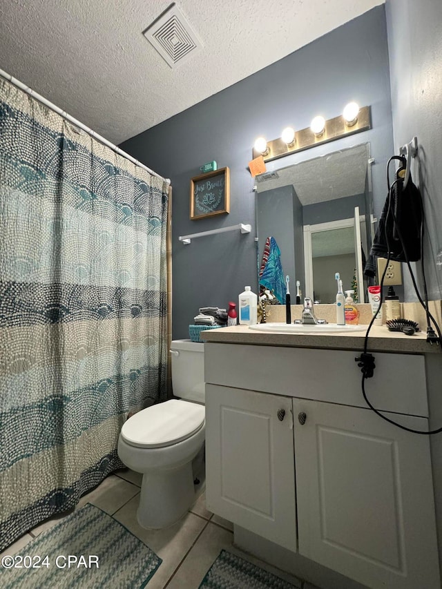 bathroom featuring a textured ceiling, a shower with shower curtain, tile patterned floors, vanity, and toilet