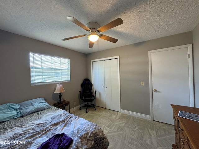 bedroom featuring a closet, ceiling fan, and a textured ceiling