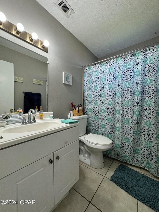 bathroom with tile patterned flooring, a textured ceiling, toilet, vanity, and curtained shower