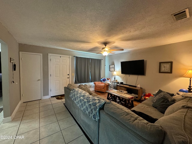 tiled living room featuring a textured ceiling and ceiling fan