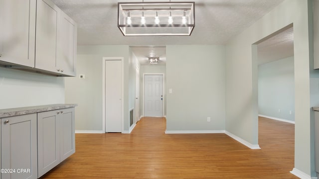 interior space with a textured ceiling and light hardwood / wood-style floors