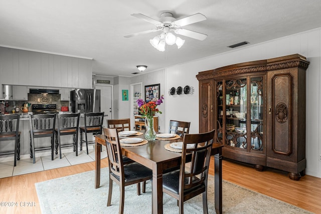 dining room featuring ceiling fan, ornamental molding, and light hardwood / wood-style floors