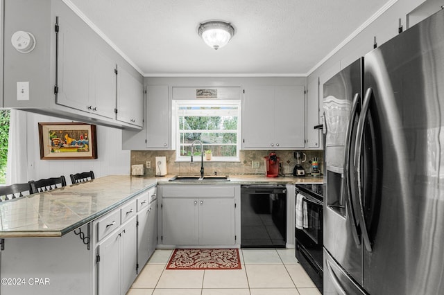 kitchen with light tile patterned floors, ornamental molding, sink, kitchen peninsula, and black appliances