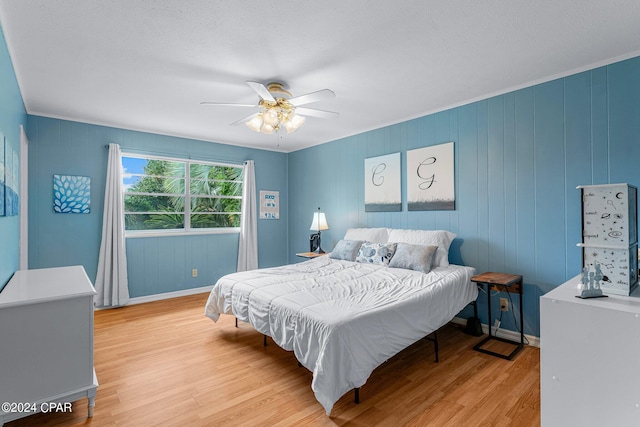 bedroom featuring ceiling fan, light wood-type flooring, and ornamental molding