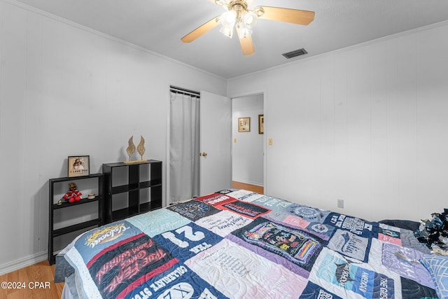 bedroom featuring ornamental molding, ceiling fan, and hardwood / wood-style flooring